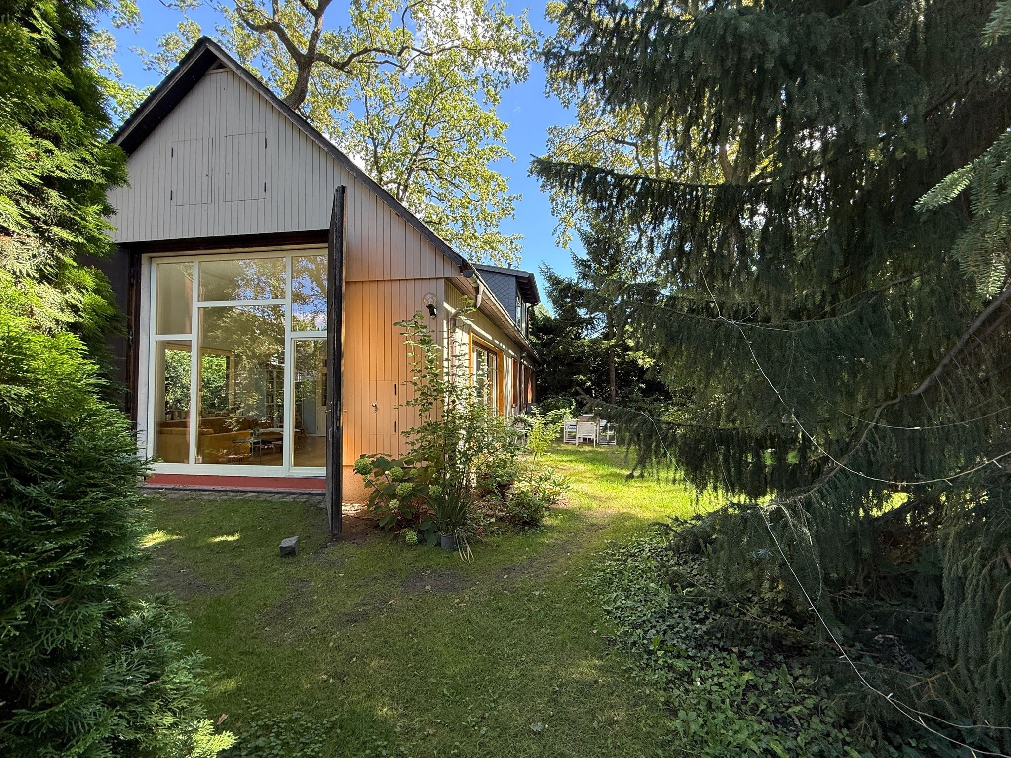 Helles Haus mit hohen Decken und hohen Bäumen in Berlin